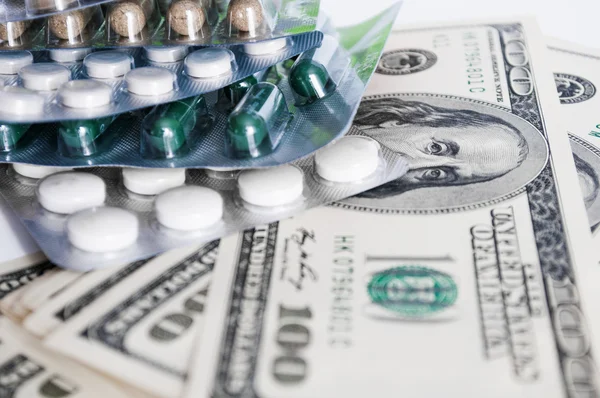 Hundred dollar bills and pills blisters close-up — Stock Photo, Image