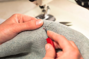 El bir Dikiş dikiş almak için kumaş bıçak kesilip