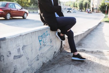 yol kenarında oturan adam