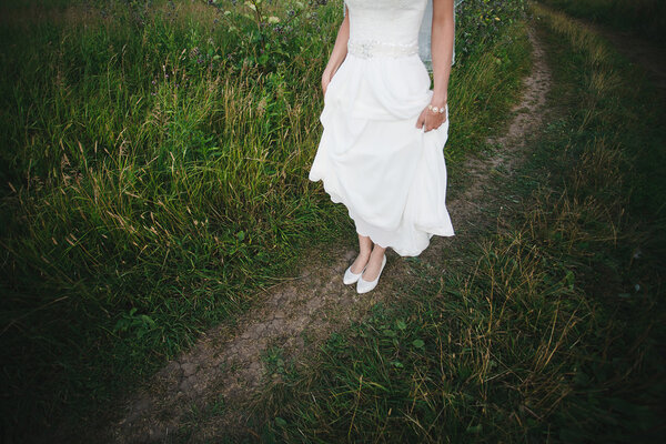 Legs of the bride on the nature grass and shoe