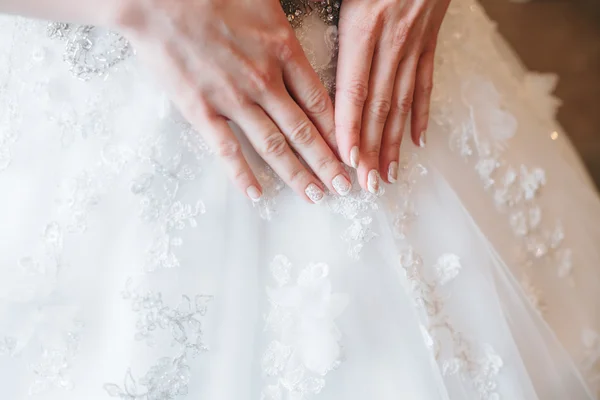 Mani sposa con manicure su sfondo di abito bianco — Foto Stock