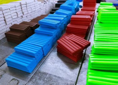 Fabrikadaki üretim hattında bir yığın plasticin var. Çok renkli mankenlik kılı. Plastik imalat endüstrisi. Çocukların sanat eğitimi için kil malzeme modelleme. Okul öncesi oyun hamuru için plastiksin.