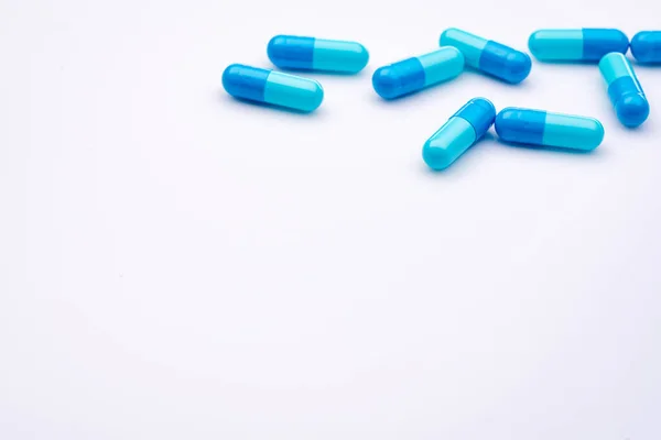 白い背景に青いカプセル薬 製薬業界 薬局やドラッグストアの製品 医療と医療 健康予算の概念 医薬品製造業 カプセル薬のグループ — ストック写真