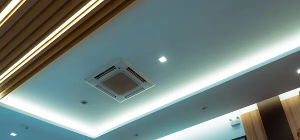Tavan duvarına monte edilmiş kaset tipi klima üzerine seçici bir odaklanma. Otelin tavanında havalandırma kanalı var. Alçıtaşı duvarında hava birimi var. Binada güzel bir sistem var. Hava akışı ve havalandırma sistemi. 