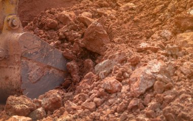 İnşaat alanında toprak kazarak çalışan bir kepçe. Kova dişli kepçe kazıcı toprak. Sürüngen kazıcı toprağı kazıyor. Kazı makinesi. Toprak hareket makinesi. Kazı aracı.