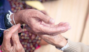 Yaşlı insanların bileklerini bağlama töreni kutsal iplikle yaşlı insanların Kwan 'ını teselli etmek için. Tayland kültürü. Kuzeydoğu Tayland halkının inançları ve yerel kültürü. Güneydoğu Asya 'da Yaşlanan Toplum.