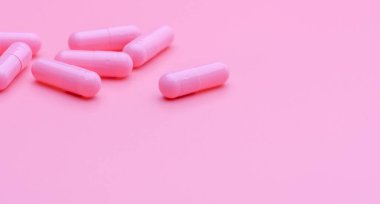 Pembe kapsül hapları pembe arka planda. Güzellik kliniğinde kırışıklık ve sivilce tedavisi için vitamin ve takviye. Eczane web pankartı. İlaç sanayisi. Mutluluk hapı.
