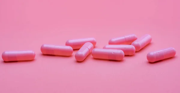 粉红色背景的粉红胶囊丸 妇女健康保险预算 药店的横幅 制药工业 维生素和补充剂 胶囊药业 快乐的药丸抗抑郁症药 — 图库照片