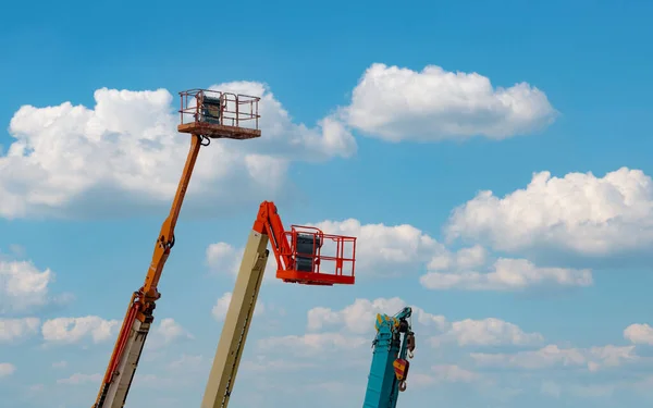 Articulated boom lift. Aerial platform lift. Telescopic boom lift against blue sky. Mobile construction crane for rent and sale. Maintenance and repair hydraulic boom lift service. Crane dealership.