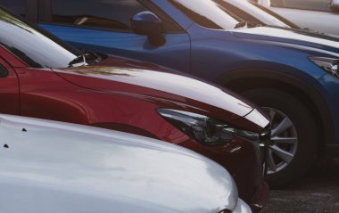 Havaalanının otoparkında kiralık bir araba var. Kırmızı, mavi SUV 'nin yan görüntüsü. Satılık ve kiralık lüks bir araba. Otomobil park yeri. Araba galerisi konsepti. Otomotiv endüstrisi.