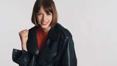 Güzel, neşeli esmer kız beyaz arka planda duygusal olarak seviniyor. Mutluluktan uçuyorum