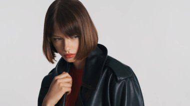 Kısa saçlı, düşünceli, üzgün, esmer bir kız. Sıradan giyinmiş. Üzüntülü görünüyor, beyaz arka planda soyutlanmış.