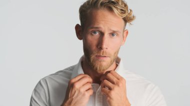 Yakışıklı, şık, sarışın, sakallı iş adamı beyaz arka planda izole edilmiş kameraya bakıyor. Yakışıklı adam.