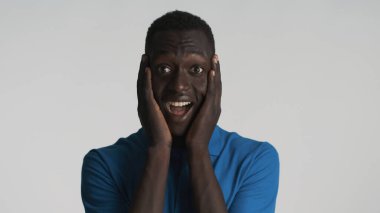 Çekici, Afro-Amerikalı adam beyaz arka planda kameraya şaşırmış görünüyor. Bu ifadeye inanamıyorum.