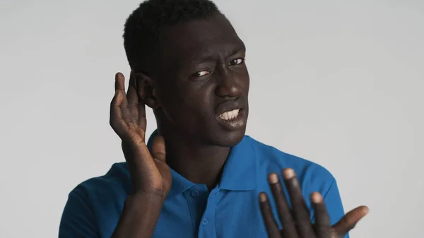 若いアフリカ系アメリカ人の男性は 白い背景の上にカメラに再び尋ね耳の近くに手を保つ ジェスチャーを聞くな — ストック写真