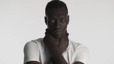 Genç üzgün Afro-Amerikalı adam, beyaz arka planda kameraya saldırarak boynunu tutuyor. Boğulma ifadesi. Siyah hayatlar önemlidir.