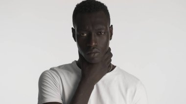 Kızgın Afro-Amerikalı adam, beyaz arka planda izole edilmiş kamerada saldırgan bir görünüm sergiliyor. Siyah hayatlar önemlidir.