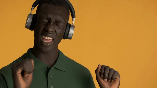 Przystojny Stylowy Afroamerykanin Słuchawkach Emocjonalnie Śpiewający Tańczący Przed Kamerą Żółtym — Zdjęcie stockowe