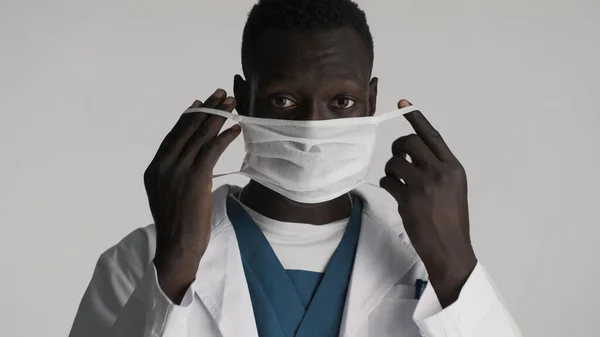 白い背景に隔離された医療マスクを身に着けている若いアフリカ系アメリカ人男性医師 安全コンセプト — ストック写真