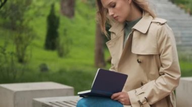 Parktaki bankta kitap okuyan güzel bir öğrencinin fotoğrafını çekiyorum. Eğitim kavramı