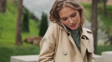 Şık, sarışın bir kızın, telefonla konuşurken, not defterine not düşerken, parkta bankta ders çalışırken fotoğrafını çekiyorum.