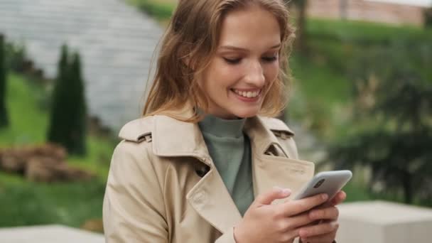Zblízka Záběr Hezká Usměvavá Blondýnka Chytrým Telefonem Vypadá Šťastný Pózování — Stock video