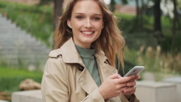 Tracking Shot Pretty Positive Student Girl Looking Happy Using Smartphone — Stock Video