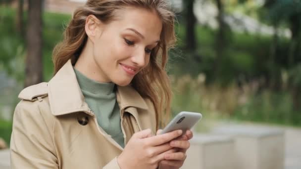 Retrato Menina Animado Olhando Feliz Respondendo Mensagens Usando Smartphone Livre — Vídeo de Stock