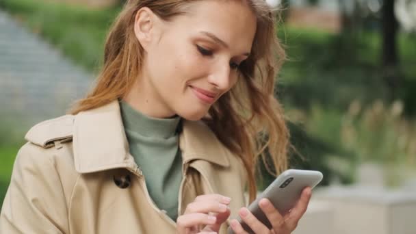 Hezká Studentka Vypadá Šťastně Rolování Sociálních Sítí Smartphone Během Procházky — Stock video