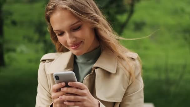 Öğrenci Kızın Erkek Arkadaşıyla Akıllı Telefondan Mesajlaşırken Açık Havada Gülümserken — Stok video
