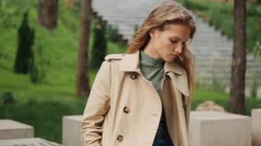 Parkta bankta oturan güzel sarışın kız. Akıllı telefondan erkek arkadaşından mesaj alıyor.