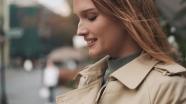 Gülümseyen öğrenci kızın kredi kartını sokakta akıllı telefondan online ödeme yapmak için kullanması.