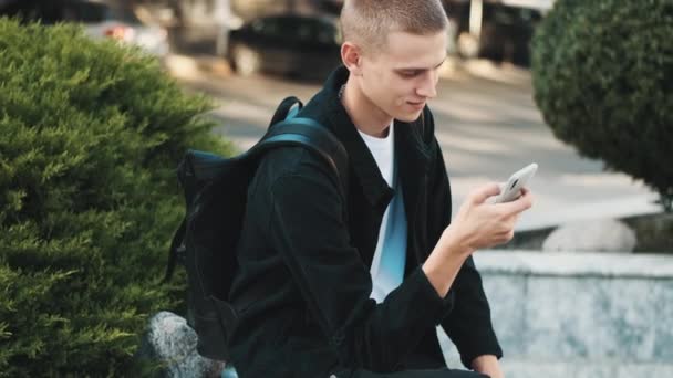 Knappe Stijlvolle Student Die Sms Sociale Netwerken Met Smartphone Straat — Stockvideo