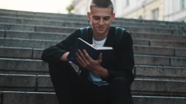Çekici öğrenci not defterine dışarıda ders çalışırken not alıyor. Eğitim kavramı