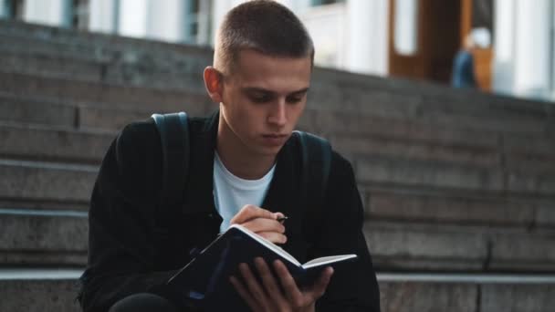 Knappe Stijlvolle Student Jongen Zoek Bedachtzaam Doen Huiswerk Notebook Studeren — Stockvideo