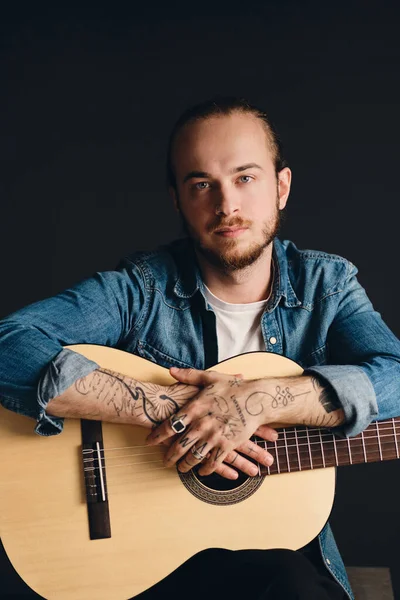 Young Tattooed Musician Intently Looking Camera Posing Guitar Black Background — Stock Photo, Image