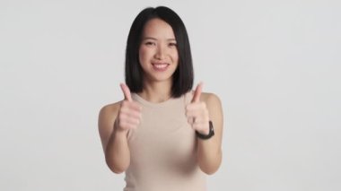 Neşeli Asyalı kadın beyaz arka planda mutlu görünüyor. Yeni iyi bir fikri onaylayan kız. Jest gibi.