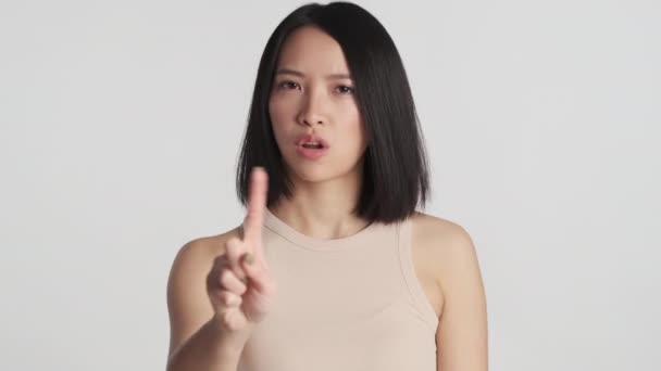 白い背景に孤立したカメラには何のジェスチャーも示さない若いアジアの女性 表現なし — ストック動画