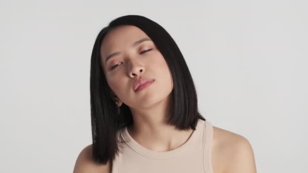 Ung Irriterad Asiatisk Kvinna Ser Uttråkad Poserar Över Vit Bakgrund — Stockvideo