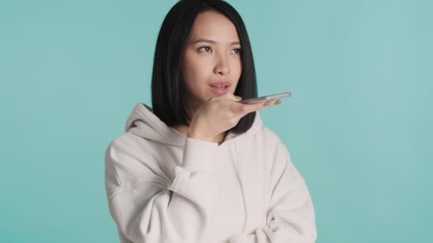 Çekici Asyalı Kız Mavi Arka Planda Izole Akıllı Telefon Kullanarak — Stok video
