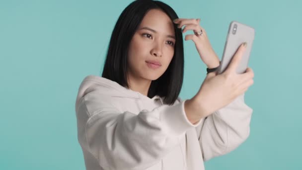후드를 배경으로 스마트폰으로 네트워크를 셀카를 아름다운 아시아 — 비디오