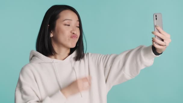 Beyaz Kapüşonlu Güzel Asyalı Kız Renkli Arka Planda Akıllı Telefon — Stok video