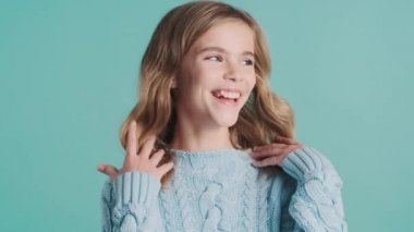 Güzel sarı saçlı genç kız renkli arka planda kameraya poz verirken sevimli görünüyor. Çekici kız.