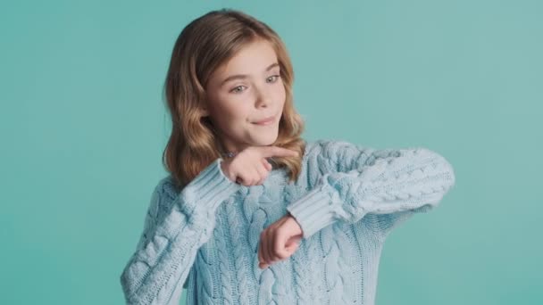 迷人的金发少女穿着毛衣示人是时候在蓝色背景的镜头前做手势了 身体语言概念 — 图库视频影像