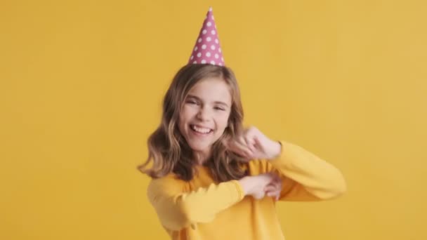 Całkiem Wesoła Blond Nastolatka Imprezowym Kapeluszu Tańcząca Urodzinach Żółtym Tle — Wideo stockowe