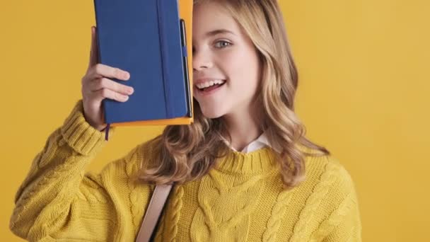 Piękna Blondynka Nastolatka Ubrana Żółty Sweter Pozowanie Przed Kamerą Książkami — Wideo stockowe