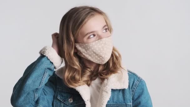 Ganska Blond Tonåring Flicka Bär Skyddande Mask Preening Kameran Isolerad — Stockvideo