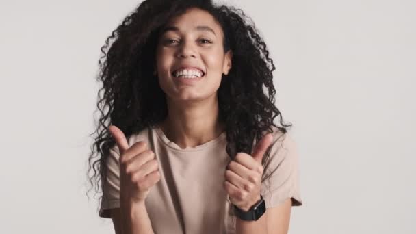 Młoda Wesoła Afroamerykanka Wyglądająca Szczęśliwą Trzymająca Kciuki Górze Białym Tle — Wideo stockowe