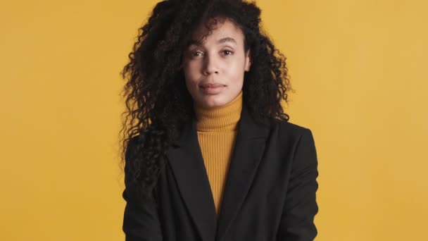 身穿经典黑色夹克的年轻的非洲裔美国女人在镜头前展示信用卡 看起来自信而不是黄色背景 业务概念 — 图库视频影像