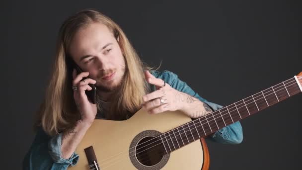 Długowłosy Blondyn Gitarą Akustyczną Rozmawiający Przyjacielem Smartfonie Próbie Studio Odizolowanym — Wideo stockowe
